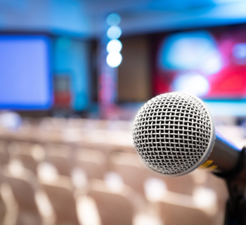 Close-up of microphone at the back of meeting room with screen projector