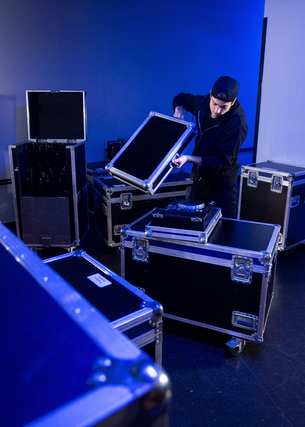 A stagehand packing up AV equipment.