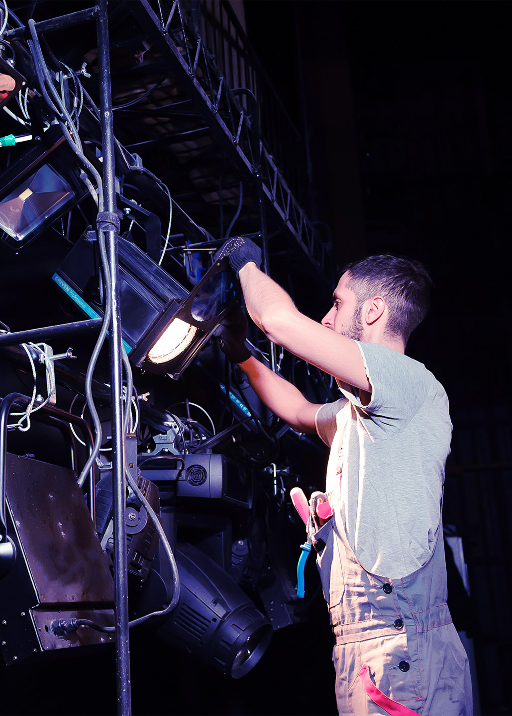 A man adjusting the lighting equipment at a live show.