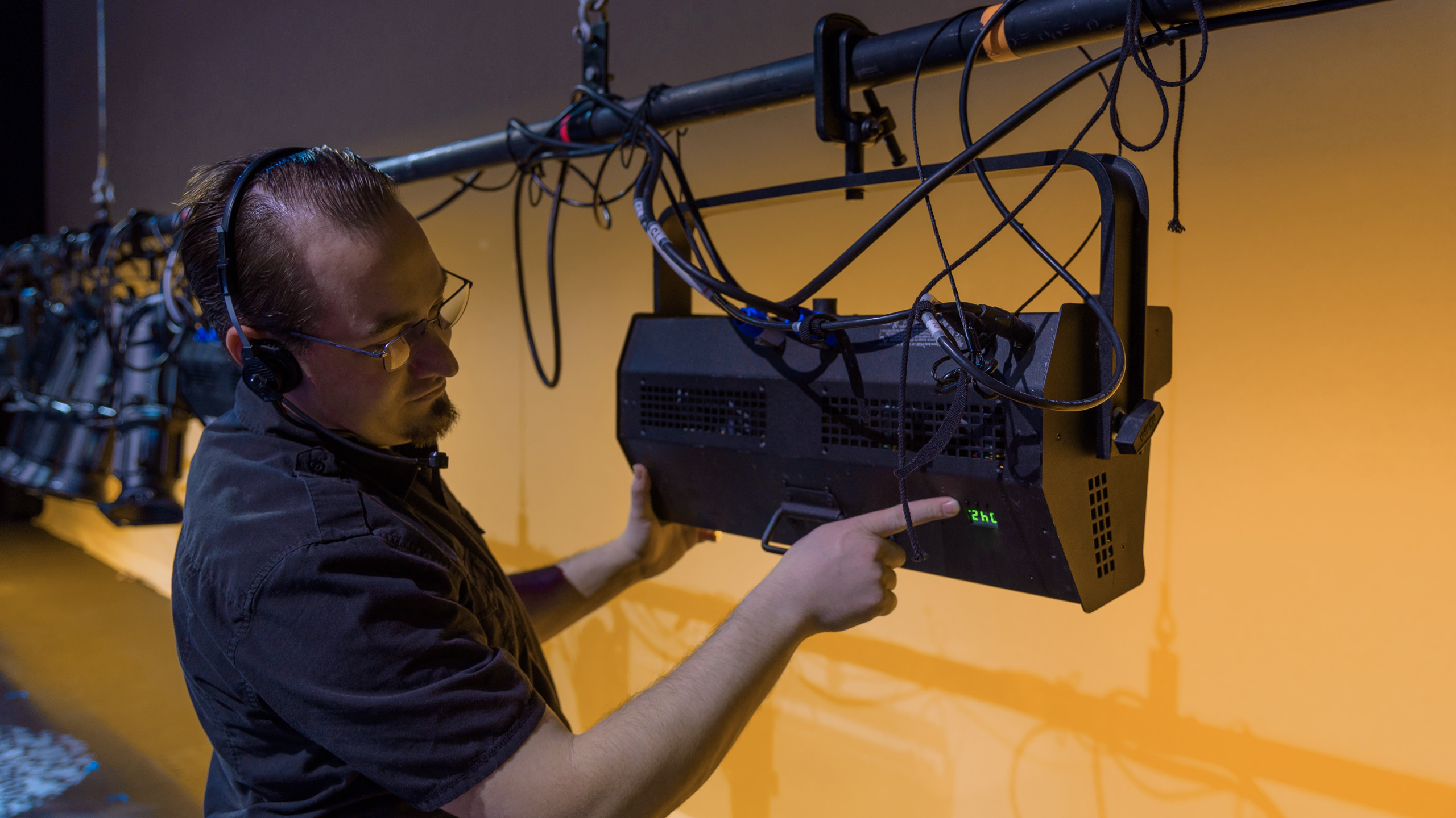 An L1 Lighting Engineer setting up a large piece of lighting equipment for a live event.