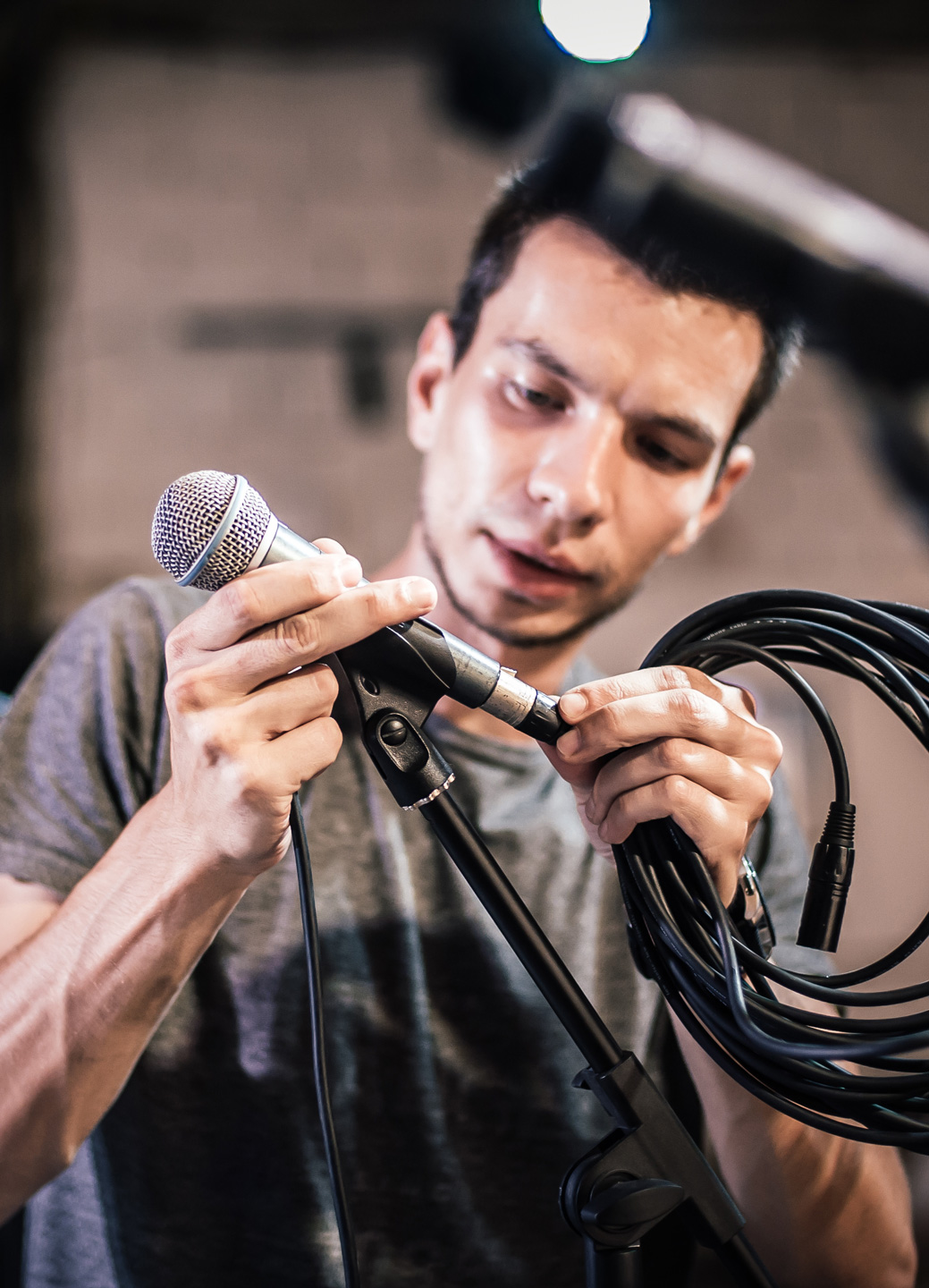An AV Tech setting up a microphone for a live show.
