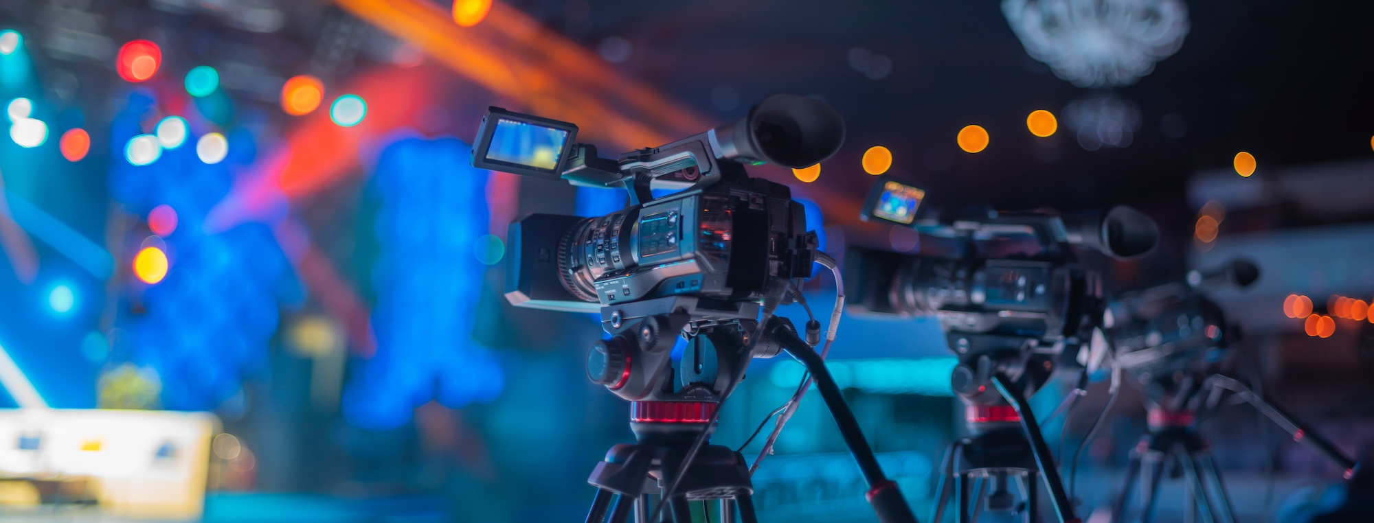 Professional video cameras on tripods streaming an event
