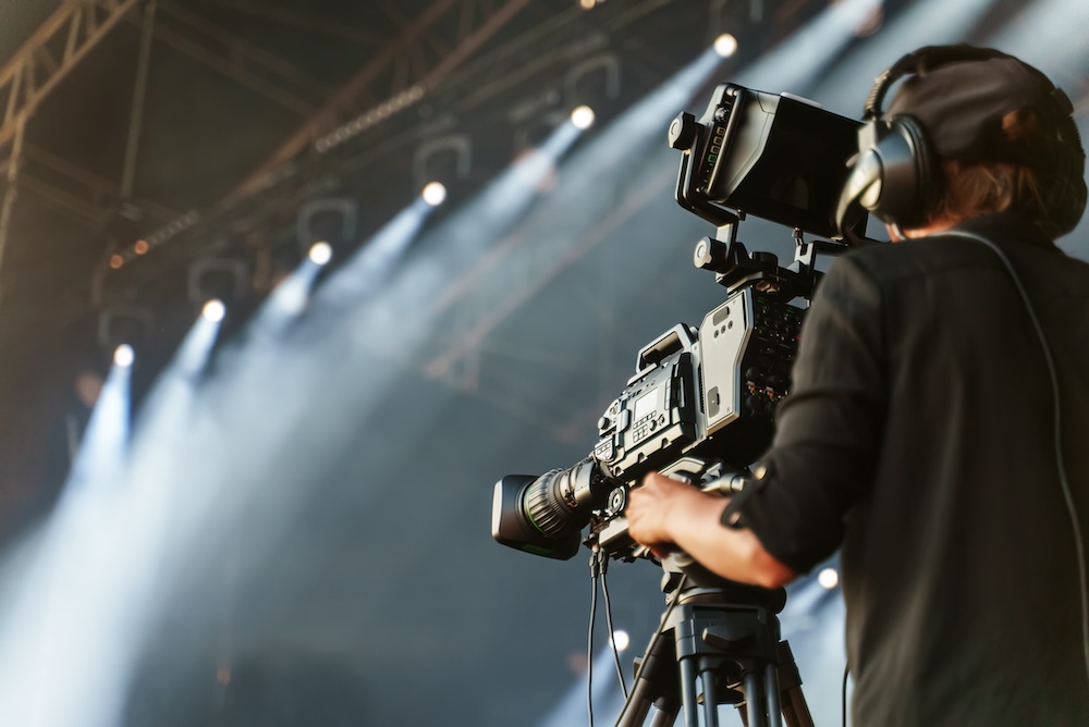 Professional camerawoman broadcasting live concert.