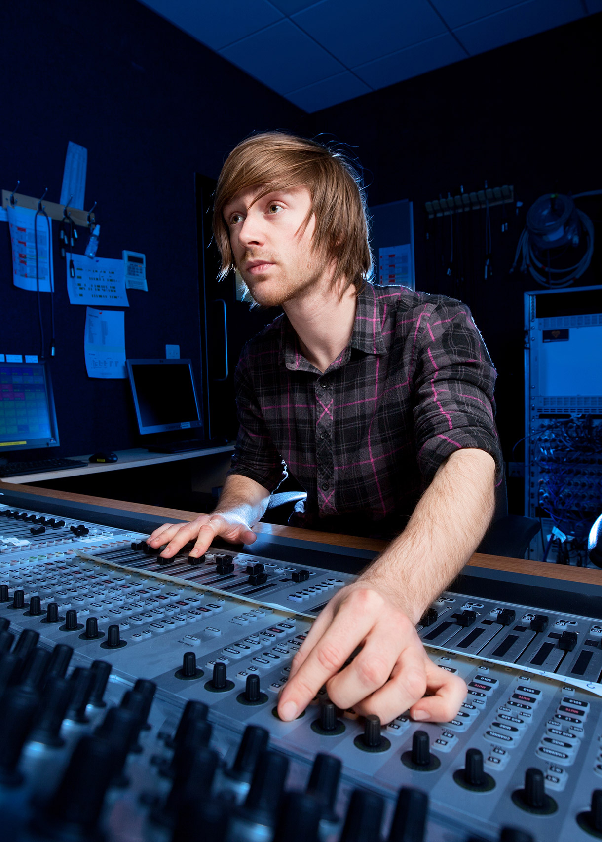 An audio engineer using a sound board inside a studio.