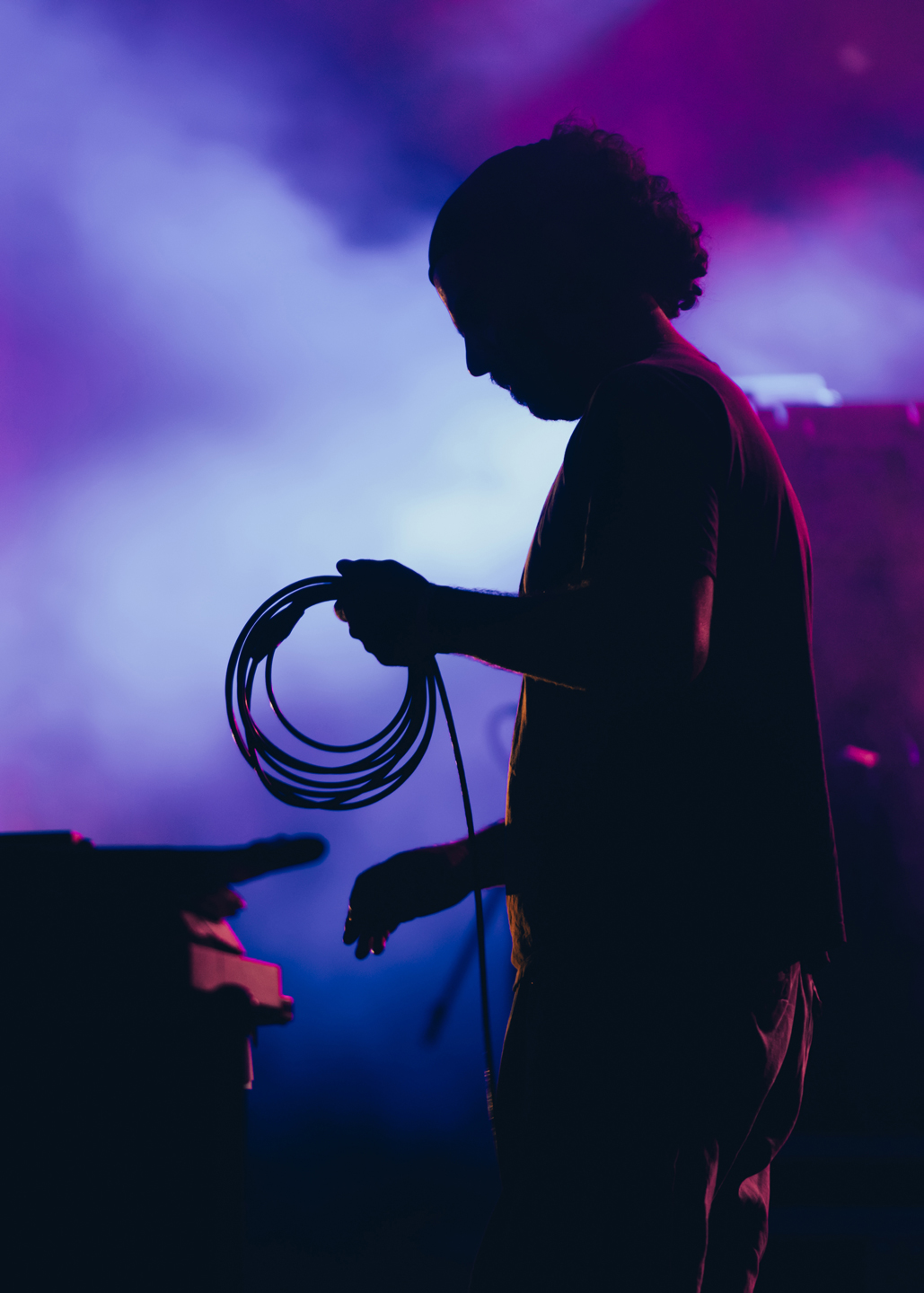 A V2 Video Engineer Assist technician's silhouette against a hazy purple background.
