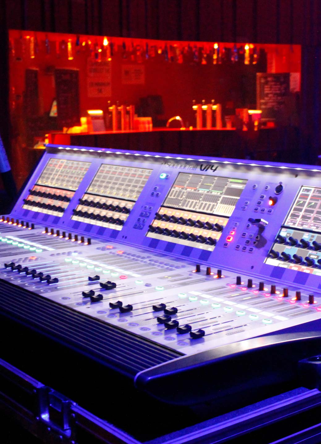 A close-up of a large, illuminated audio mixing console