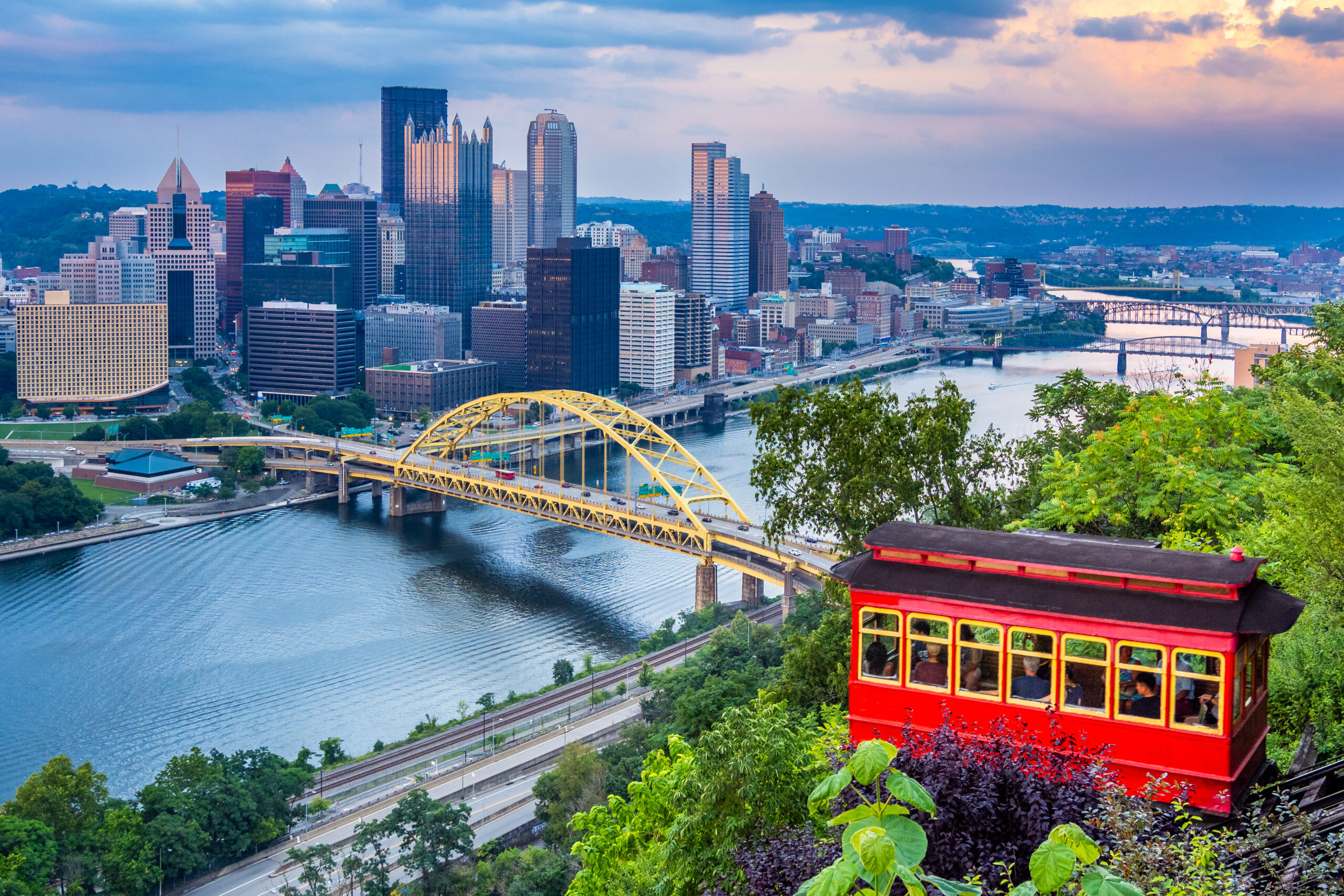 Red car of Duquesne Incline with Pittsburgh downtown panorama on background at sunset.