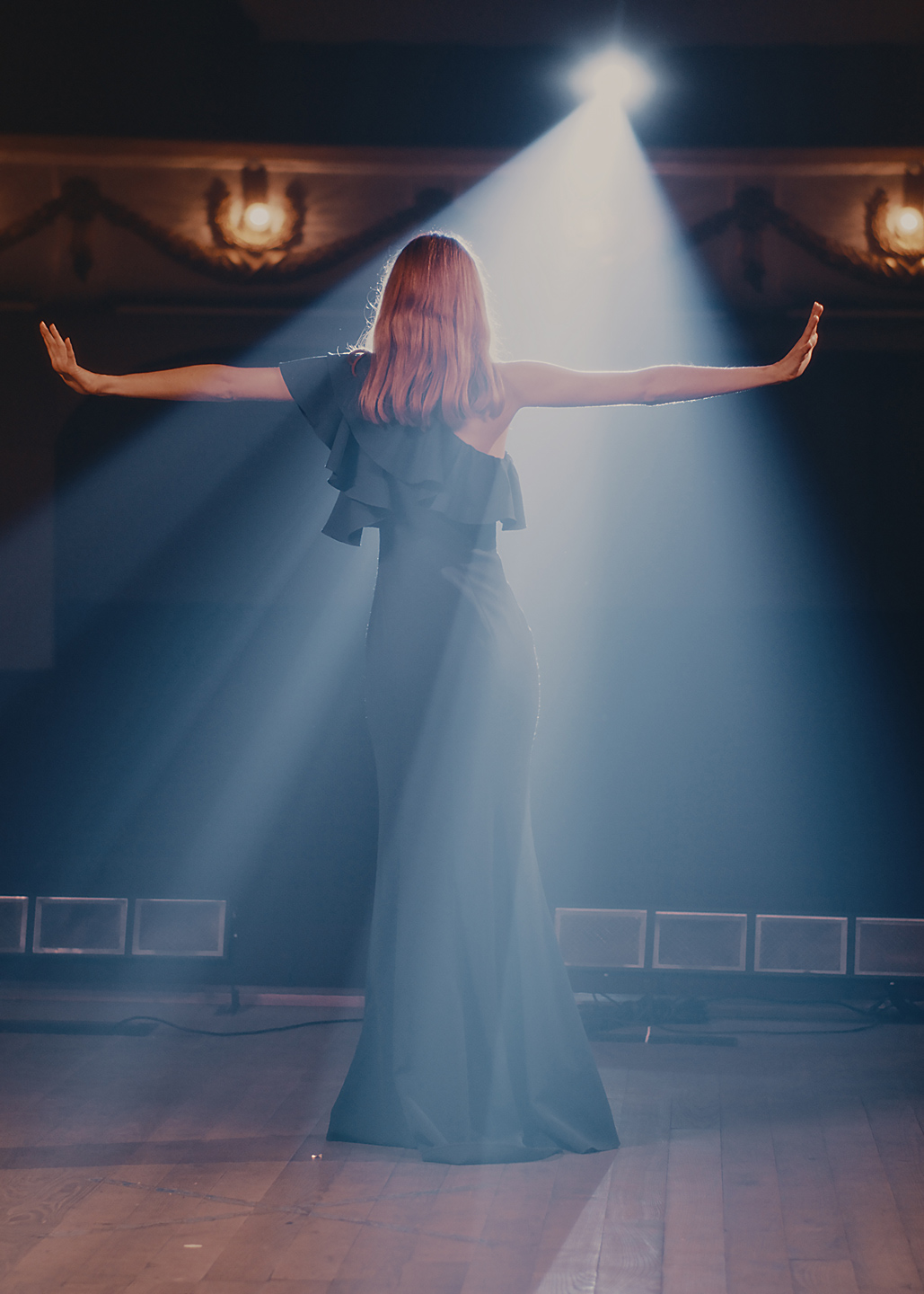 A woman onstage in a spotlight